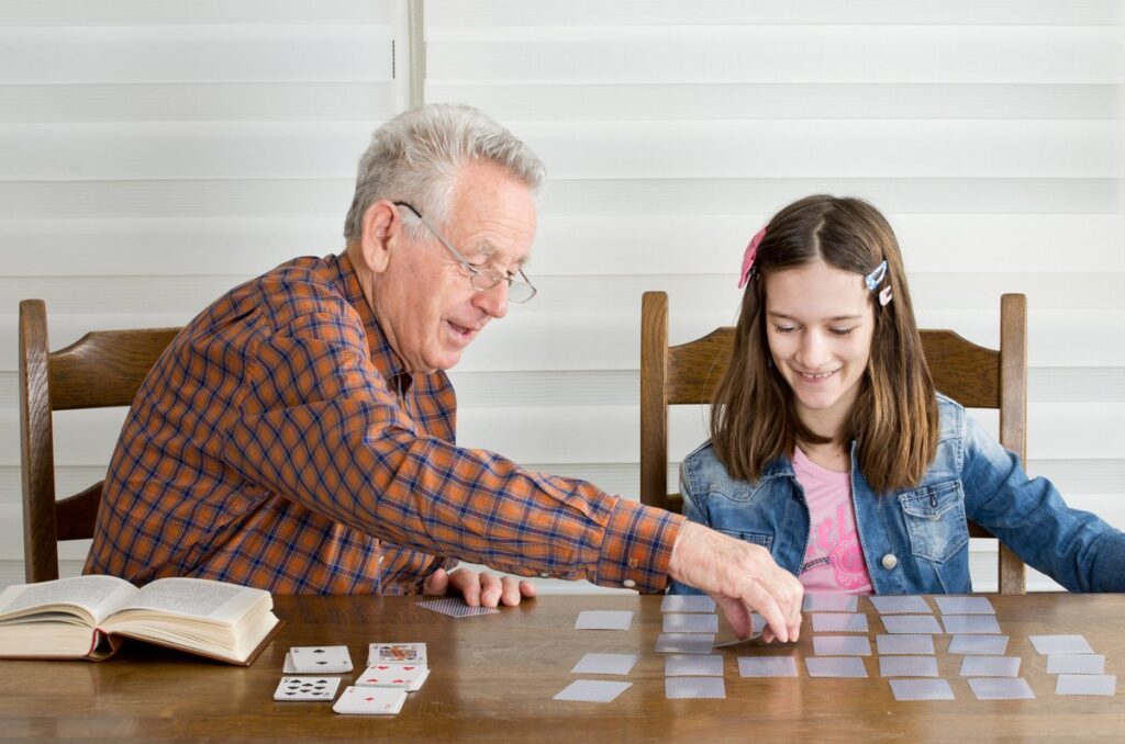 Anciano jugando juego de mesa con su nieta